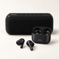 Set Vörmann Duo: parlante Strum negro junto a los auriculares Pulse y su estuche de carga.